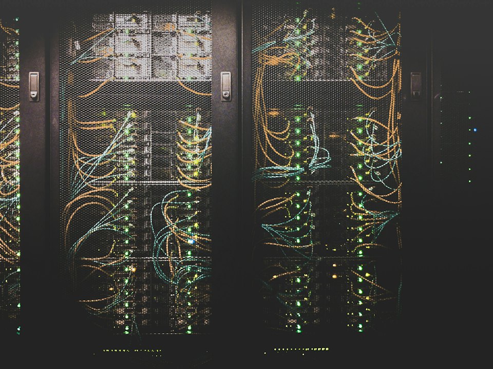 Server racks wired with bundles of coloured cable